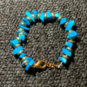 Nytt armband med blåa stenar och guld -pärlor.  Med ett gummi band som är töjbart.