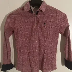 En stilig Polo Ralph Lauren skjorta för dam i röd med design(zooma in). Använd men bra skick, kan behöva strykas lite men inget mer. Storlek 38 passar S och Xs