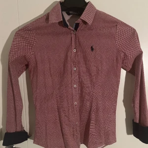 Ralph Lauren skjorta dam - En stilig Polo Ralph Lauren skjorta för dam i röd med design(zooma in). Använd men bra skick, kan behöva strykas lite men inget mer. Storlek 38 passar S och Xs