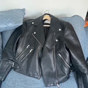 Svart faux skinnjacka  - Svart skinn jacka med silver detaljer. Jackan är från Asos i strl M och jag har  använd ett par gånger men är i gott skick och lika snygg som ny. Vid snabb affär kan jag pruta ned lite priset och ingen skambud tack! 