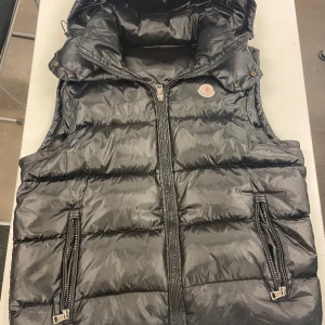 Moncler väst - Haft den i ca ett år. Knappt använd legat i min garderob i flera månader inget fel med västen inga defekter eller något liknande  Skick:9/10 Priset är ej hugget i sten. R3plika