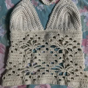 Virkad tipp - En virkad topp av mig som är gräddvit. Skulle säga att kupan passar b/ c? Storleken är M (är 73cm lite över midjan där man knyter den, så skulle inte säga att den passar 70cm och under!!) säljer för 200 + frakt !! Ska handtvättas!!