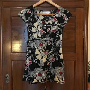 Söt blommig blus - Säljer denna blommönstrade blus som har två stora coola knappar på framsidan! Den har band på baksidan som man kan knyta så den passar nog både S och M, fråga om mått om ni undrar! 🍓❤️🌹