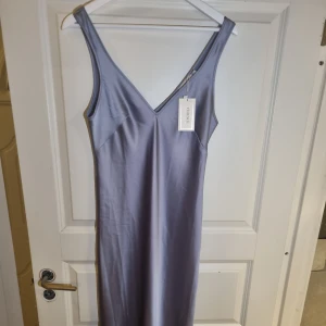 Silkes klänning - Lång klänning från asos. Aldrig använd då den inte riktigt  passade. Storlek 38. Jag är 166 lång och den går till ankeln. 