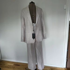 Oanvänd kostym Stockh LM - Oanvänd kostym i linné frpn Stockh LM Nypris kavaj: 1300 kr Nypris byxor: 900 Säljer hela set för 1000 kr