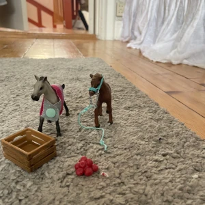 Leksaker  - Två föl, ett föl täcket, en föl grimma, en låda och en hög äpplen 