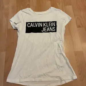 Vit Calvin Klein T-shirt med svart tryck. Använd 1 gång så den är nästan som ny! 