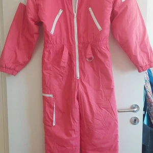 Skid-overall 1980-tal Oanvänd - Skid-overall märkt storlek 170 cm lång. 1980-tal Ny med lappar kvar. Resor i midjan, tre fickor Vida snygga ärmar Midja 80 utan töj Byst 108 cm Innerlängd ben 78 cm  Axelsöm -grensöm fram 74 cm, bak 80 cm