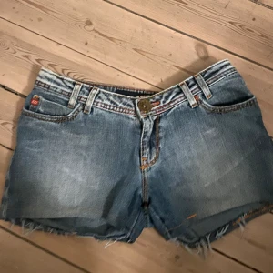 Shorts med design  - Ett par sjukt snygga lågmidjade shorts med design på bakfickorna! Inga defekter, men säljer då de tyvärr var för små för mig. Midjemått: 37.5cm. Längd: 30cm. Benöppning: 26cm.