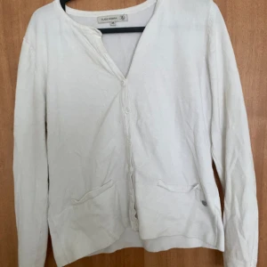 Vit kofta - Jätte fin vit kofta, har knappdetalijer längst ner på armarna, jätte bra skick, säljer då jag inte får användning av den. Storlek M men passar S också, skriv om du vill ha fler bilder!