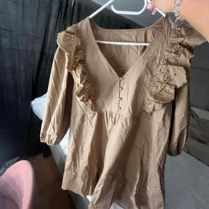 Brun klänning 🤎 - Säljer denna söta klänning från Pernilla Wahlgrens kollektion på Ullared. Köpt för ett halvår sedan och aldrig använt den. Den var för stor för mig därav säljer jag den.
