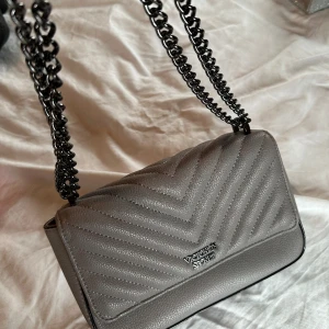 Handväska - Superfin väska från Victoria’s secret. Använd vid något enstaka tillfälle så i superfint skick. Något ljusare grå i verkligheten än på bilden. 