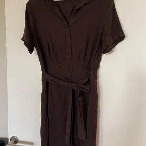 Brun linneklänning  - Linneklänning jag köpte för att ha under graviditeten. Är nu förstod för mig. Knappt använd, tvättad en gång. Utan anmärkning.