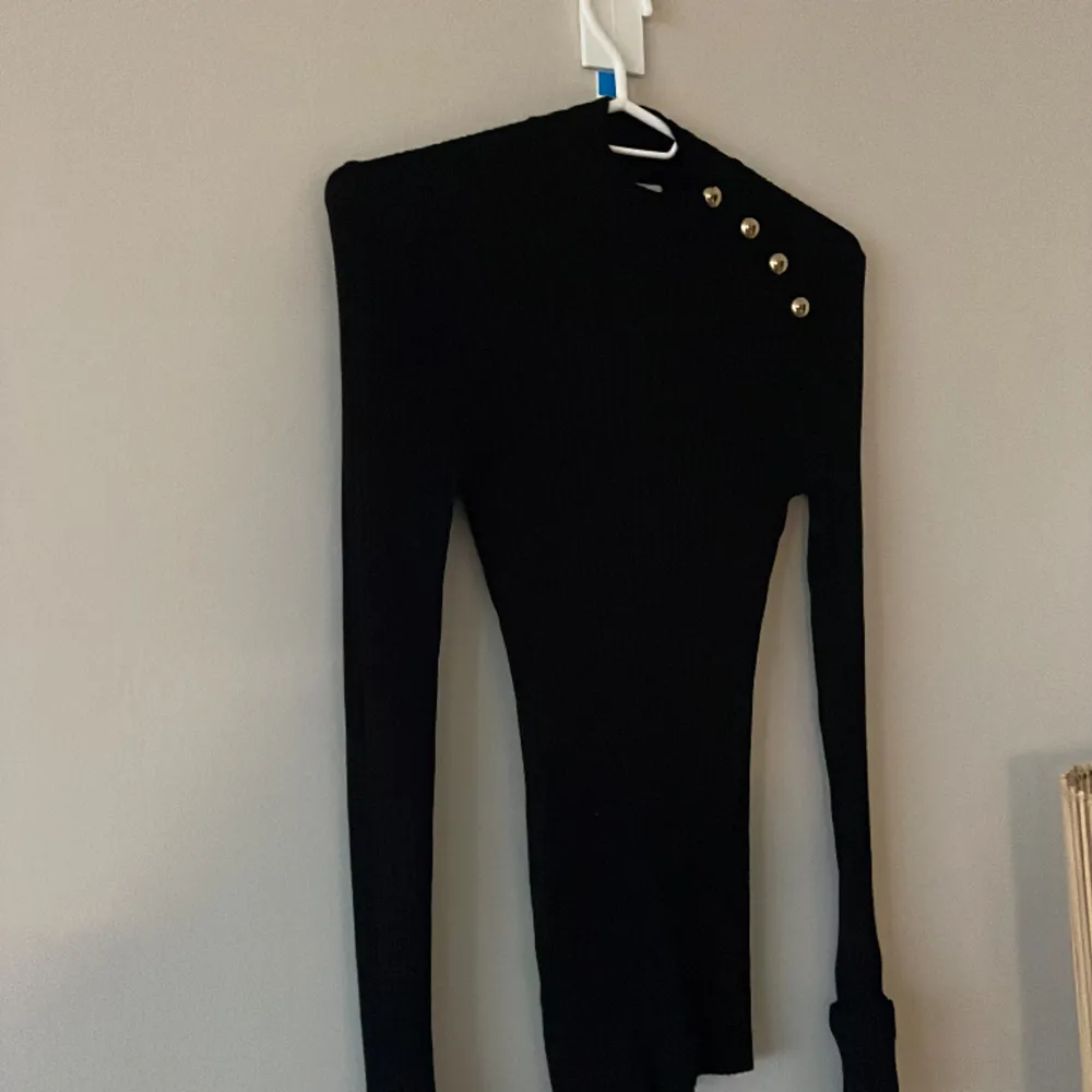 Ribbad svart tröja med guld detaljer/knappar på ena sidan. Från H&M i strlk XS.  . Tröjor & Koftor.