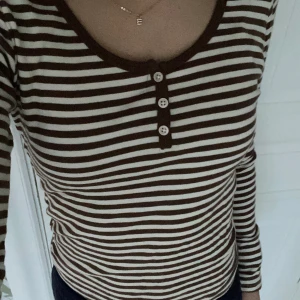 Brun och vit randig tröja - En brun och vit randig tröja med knappar från Brandy Melville💗