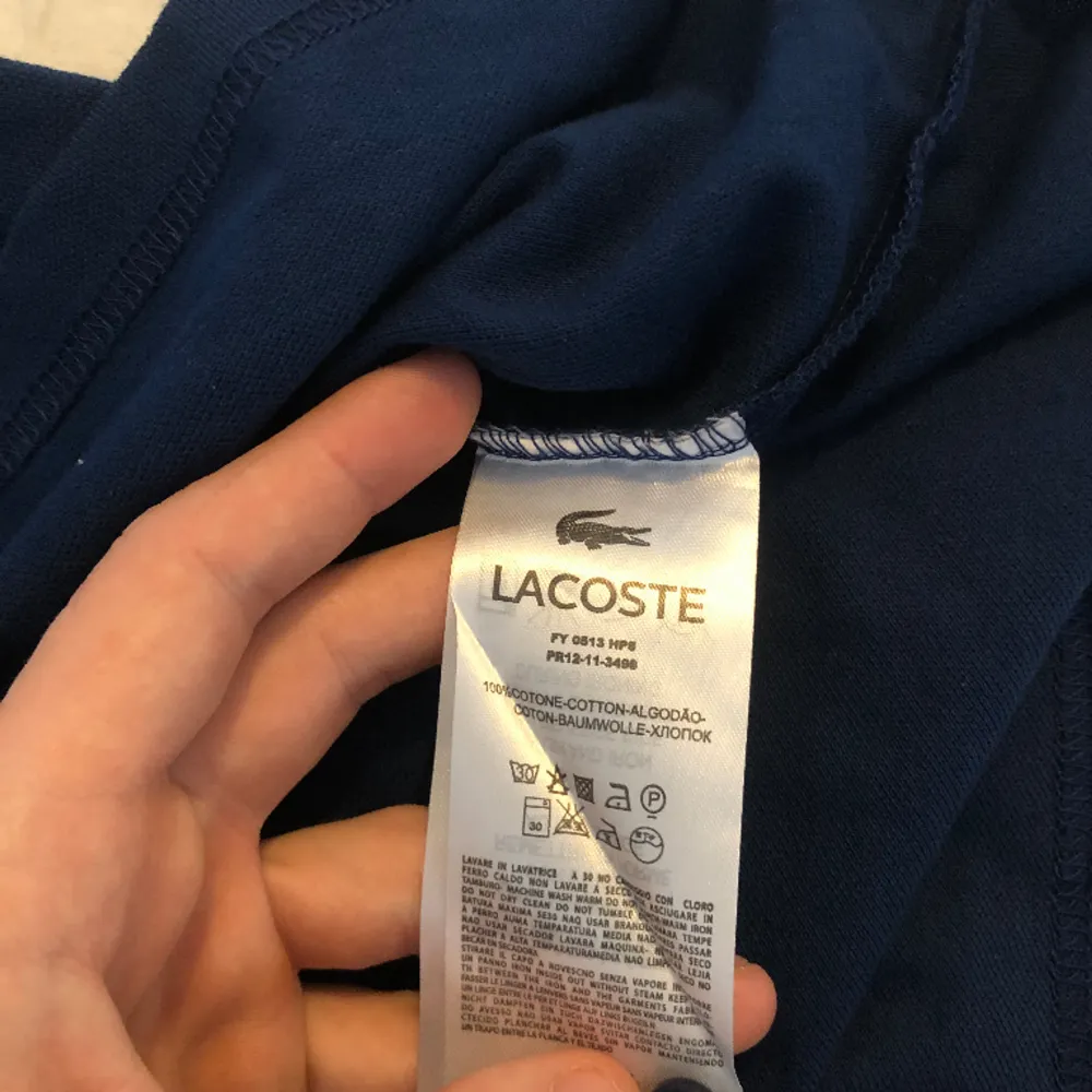 Polo Lacoste, i mycket gott skick, färg mörkblå, size L. T-shirts.