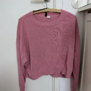 En stickad rosa tröja från H&M i storlek L fast fast passar mindre också Pris 99kr