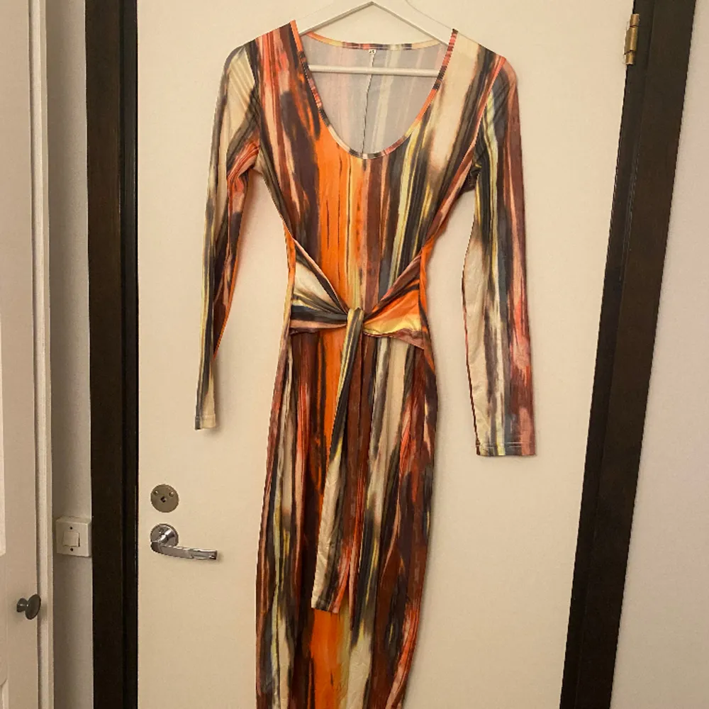 Använd 1 gång, orange klänning med knytning i storlek Xs, vintage och säljs inte i butiken längre🌺. Klänningar.