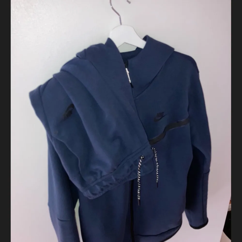 Fin Nike Tech Fleece dress i navy blå. Mycket bra skick! Koftan är M och byxor är L. Köptes för 2250kr och säljs för 1300kr. . Hoodies.