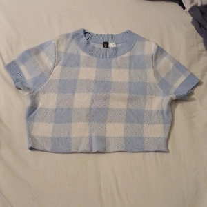 Rutig Blå och vit magtröja  - Magtröja med två färgade rutor på, blå och vit. Supersöt och helt ny. Materialet är sjukt skön, känns som en stickad mysig tröja. Köpte för 150kr men säljs för 60kr. Utan hål och utan några slitningar!