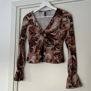 Blus - Långärmad blus med volang i ärmarna. 