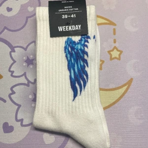 Weekday strumpor - Ett par weekday strumpor med blåa vingar på sig. Säljs för att de inte är min stil. Använd gärna köp nu!