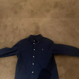 Ralph lauren mörkblå skjorta - Säljer min mörkblåa Ralph Lauren skjorta för 350 kr. Perfekt skick, tyvärr för liten för mig nu. Perfekt för alla tillfällen och ett riktigt kap! Intresserad? Hör av dig! 
