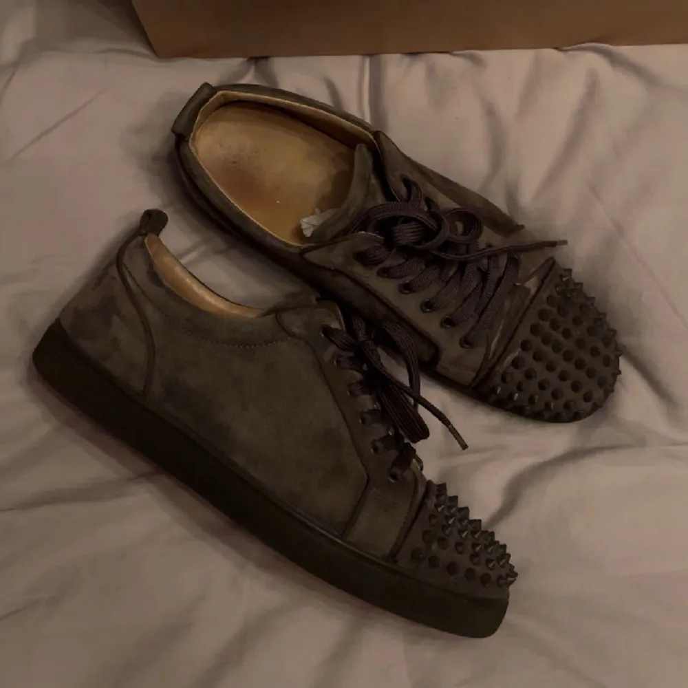 Säljer nu mina Louboutin skor i grå mocka. Skicket är bra, men de är använda. Inga skador. Extra skosnören och spikes tillkommer. Dustbag, låda och kvitto finns. Köpta i Louboutin butiken i Madrid för ungefär 2 år sedan. Fler frågor och bilder i DM.. Skor.