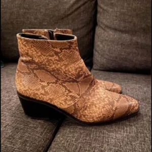 Boots  - Oanvända boots i storlek 38. Ormmönster. Oäkta skinn. Ev. frakt betalas av köpare. 