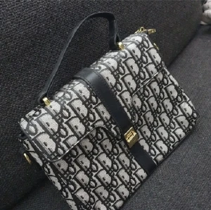 Dior handbag väska handväska  - Ej från butik! 2000kr ny med tull och frakt avgifter från Hongkong. Cirka 24 cm längd, 8-9cm djup, 19 cm höjd. Black/grey pattern i skinn med gulddetaljer. Perfekt skick, axelrem medföljer. Hårdvaxad yta. Kolla gärna mina andra annonser för fynd