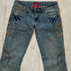 Lågmidjade jeans - Säljer dessa skitsnygga lågmidjade jeans med snygga detaljer på sidan💕Midjemått: 78 cm innerben: 86 cm Finns ett litet hål på nedre benet som visas på sista bilden. Jeansen är väldigt stretchiga 