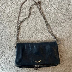 Zadig väska rock - Säljer min Zadig&Voltaire väska då den inte kommer till användning längre tyvärr. Båda kedjorna fås med och alla dragkedjor funkar🤗 Viss slitning på väskan och slitningar på kedjorna finns, syns på bilderna🩷