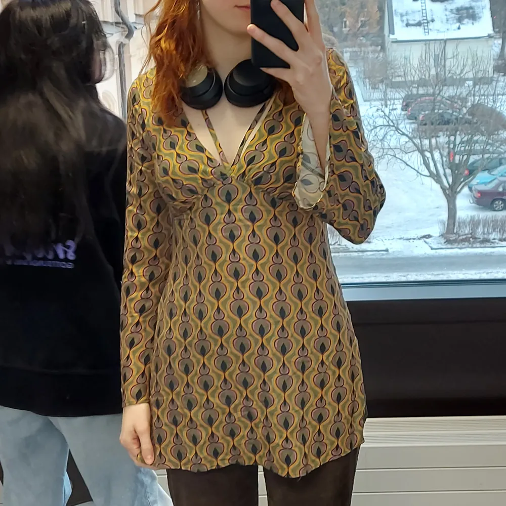 Grön tunika med orangea och rosa detaljer. 70-tals vibe med lite utsvängda ärmar. Jag har sytt om den lite, den var en klänning men var för kort så gjorde den till en tröja. Från pull & bear i storlek M.. Puserot.