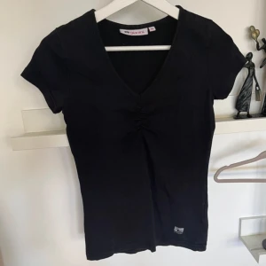 T-shirt - Med ”drag” i v-ringningen.  