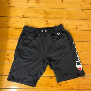Champion shorts svart - Svarta shorts av märket champion. Storleken är L men passar bra för M om man gillar baggy shorts. Använda ett par gånger men i bra skick. Pm för mer info och bilder. 