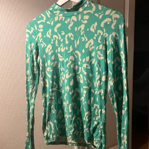 Fin grön långärmad tröja i leopard liknande mönster, tröjan har en liten krage som man ser på bild 1 och 2, köpte i samband med ett klädtema i grönt, aldrig använt efter det💕