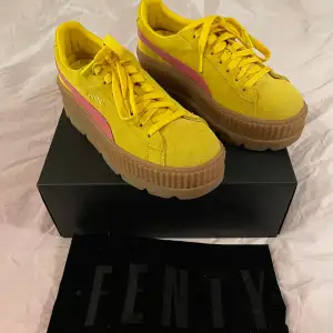 Gula sneakers i platåmodell med rosa detaljer från Fenty Puma. Sparsamt använda och i fint skick! Storlek 40.