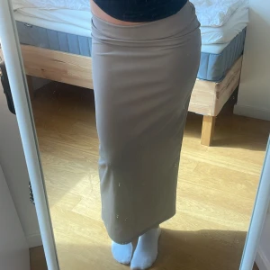 Lågmidjad långkjol - Lågmidjad beige långkjol med slits där bak som inte märks så myclet förutom att det blir lättare att gå i den🥰Aldrig använd🙌
