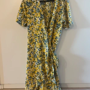 Omlott klänning från samoe samoe  - Fin blommig omlott klänning från samoe samoe. Gul botten och blommor. Knappt använd. 100% viskose
