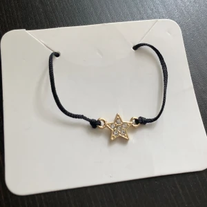 Litet armband med stjärna, guld, strass, tråd, dainty, nätt, stilren, oanvänd - Nätt armband med en guldfärgad stjärna med strass. Diameter stjärna: 1 cm.