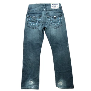 True religion jeans - Feta jeans från true religion, klassiskt tryck. Lite slit som kan ses på bilderna. Benöppning: 19,5cm Ytterben: 100cm innerben: 70cm midja: 39cm Skriv gärna frågor😊
