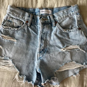 Jeans shorts - Fina blåa midwaist, slitna jeans shorts ifrån Zara. Säljs då de tyvärr är försmå. 