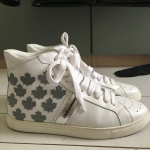 Dsquared2 sneakers - Ett par höga vita Dsquared2 skor i bra skick, lite smuts på ett skosnöre men inget märkvärdigt, Använda kanske 3 gånger.
