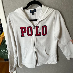 Polo Ralph lauren hoodie - Snygg vit polo Ralph lauren hoddie i bra skick. Hoodie har en logga i stilren logga i mitten och huvtröjan består av bomull. Storlek 14-16 år.