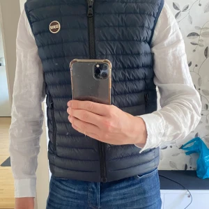 Colmar väst - Säljer denna feta mörkblåa colmar väst då den är för liten. Den har en liten defekt men inget man tänker på. Skulle säga att västen passar bäst till längden 175-180cm.