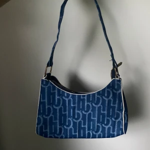Denim minibag - Jeans material, dragkedjan fungerar som den ska:) Den har dock inga fickor på insidan
