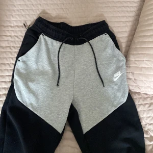 Nike teech byxor - Hej köpta för ungefär ett år sedan och börjar bli små därför jag säljer dem, Deme ganska bra skick bara att zip sakerna gått sönder lite men funkar fortfarande 