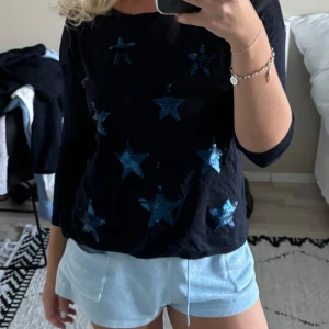 Tunn stickad tröja med stjärnor - En marinblå tunn stickad tröja med blåa paljettstjärnor. Superskön! Passar xs-m. 
