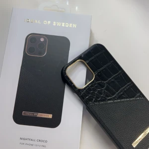 IDEL OF SWEDEN skal  - Ett svart skal med guldiga detaljer. / För iPhone 12/12 PRO. Säljer detta för att jag inte använder det längre 💕