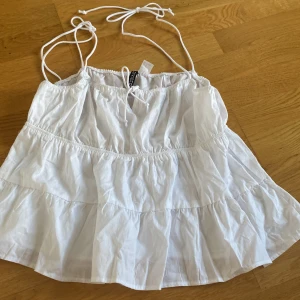 Vitt linne med knytdetalj - Jätte gulligt vitt linne från hm 💕Perfekt till sommaren då det är svalt och passar perfekt till massa outfits, skriv om ni vill ha fler bilder💕💕Säljer den då den inte kommer till användning, den har inga defekter och säljs ej längre på hm!